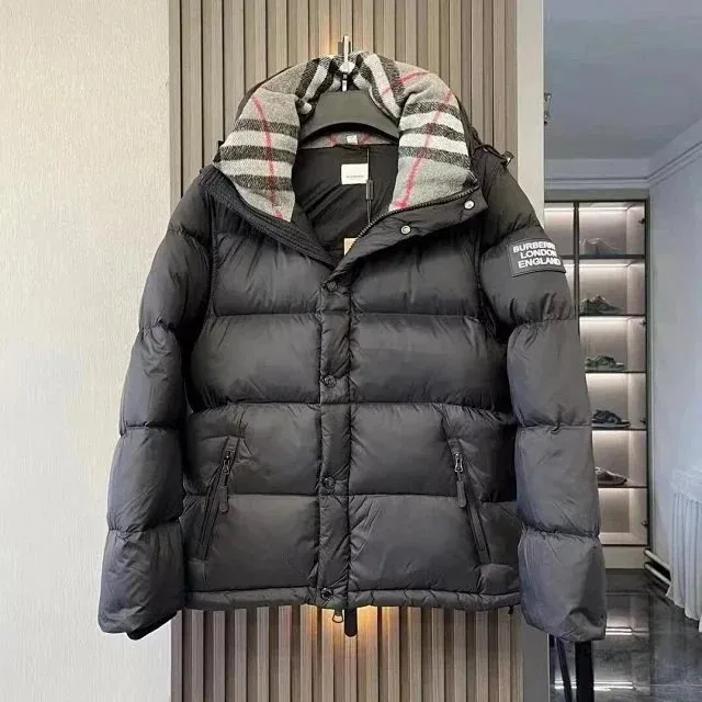 Black Burberry puffer jacket with a plaid hood lining and sleeve patch on a hanger.