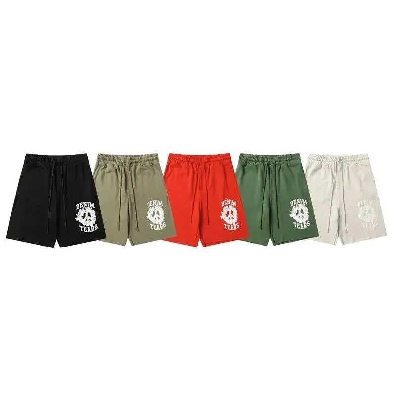Denim Tears shorts laid flat with bold white front-leg graphic text and drawstring waist.