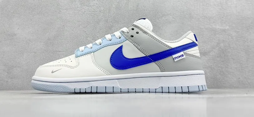 Nike sneakers w białej kolorystyce z dużym niebieskim Swooshem, widok z boku.