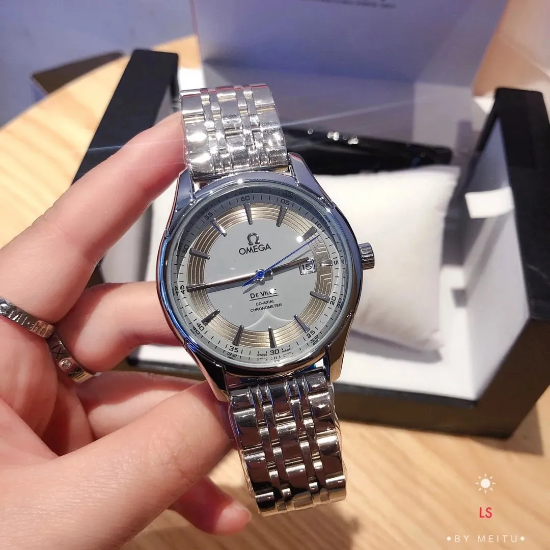 Omega De Ville zegarek na srebrnej bransolecie, z niebieską wskazówką i datą.