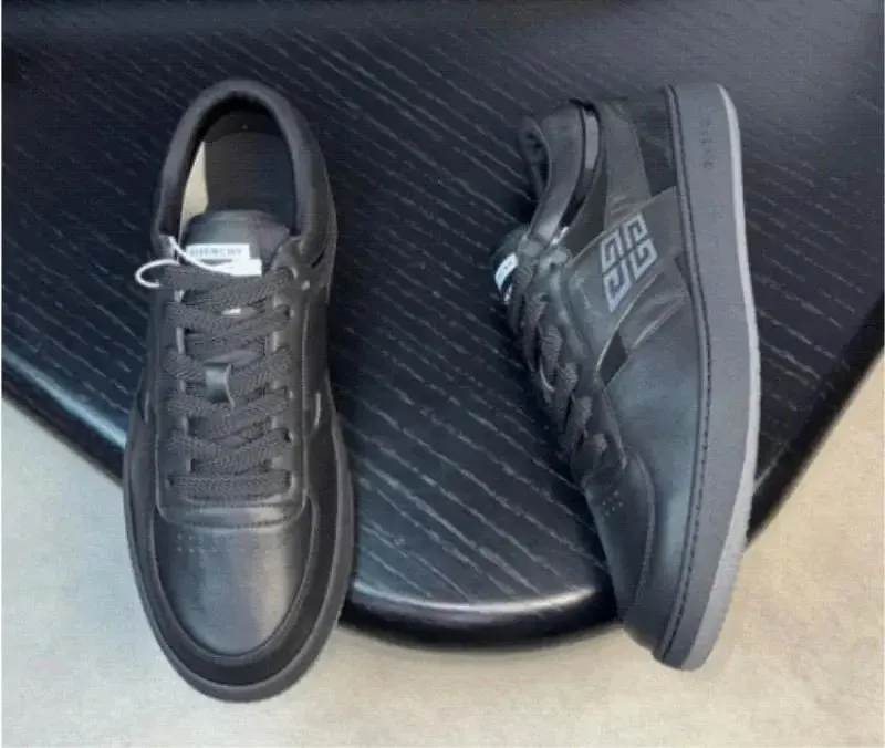 Givenchy black low-top sneakers with side logo mark and contrast sole edge.