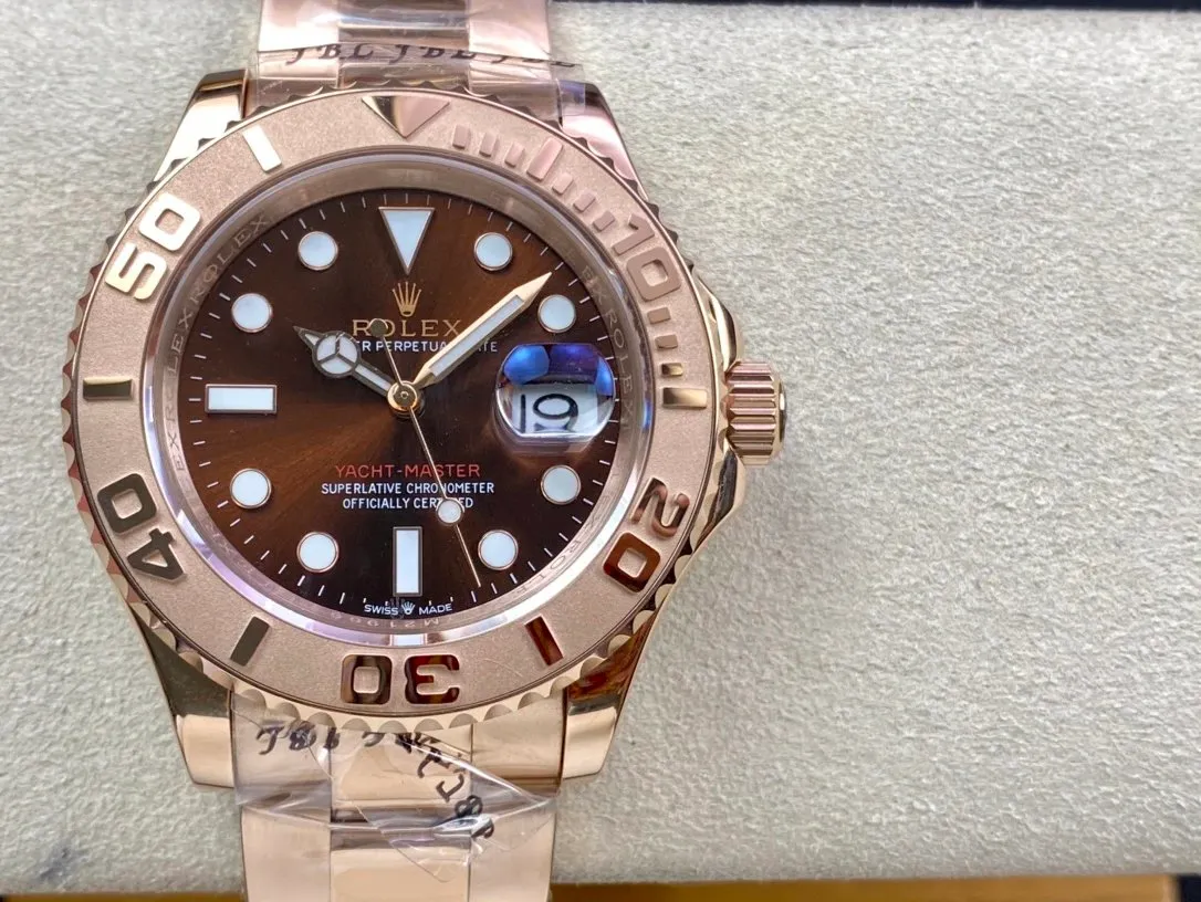 Rolex wristwatch with a brown dial, rose gold-tone case, and metal bracelet on a gray surface.