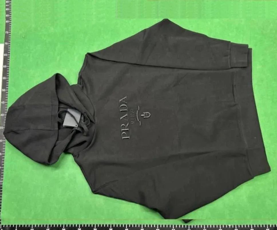 Black Prada hoodie with chest embroidery, a relaxed boxy fit, and visible drawstrings.