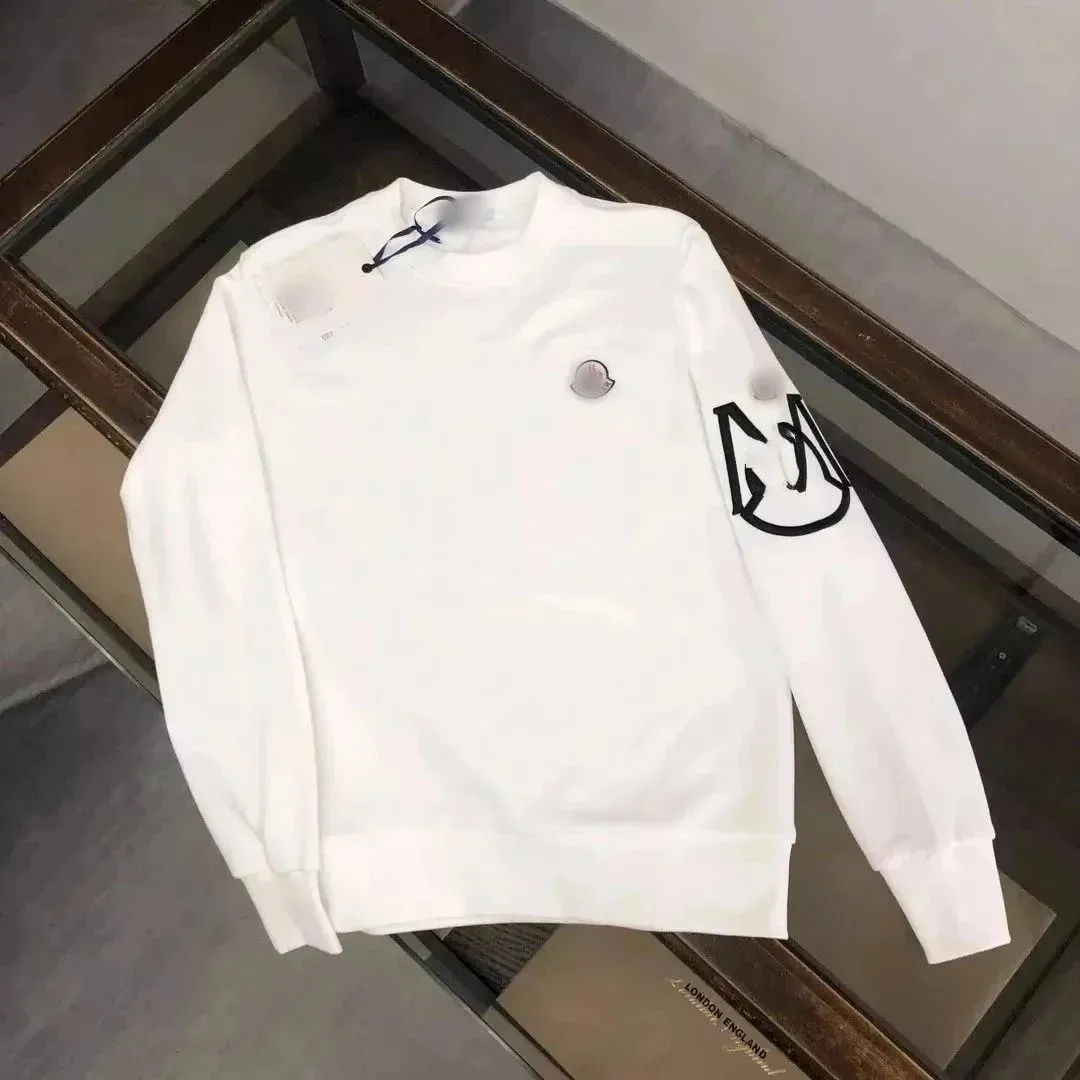 Moncler white sweatshirt with chest patch logo and bold black sleeve graphic.