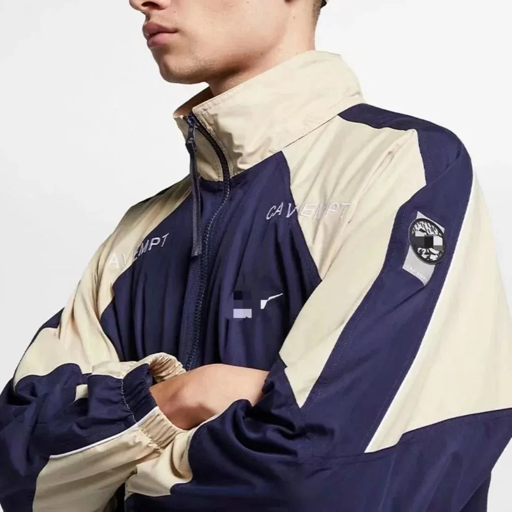 Cav Empt colorblock athletic jacket with navy, cream, and black panels in a boxy fit.