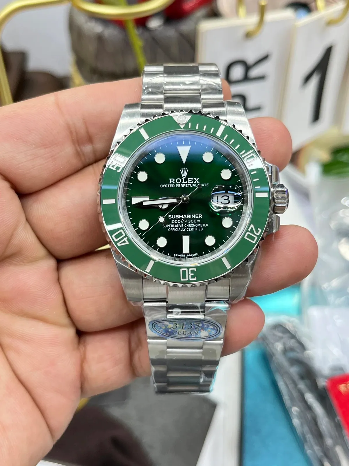 Rolex Submariner watch with green bezel, black dial, and metal bracelet.