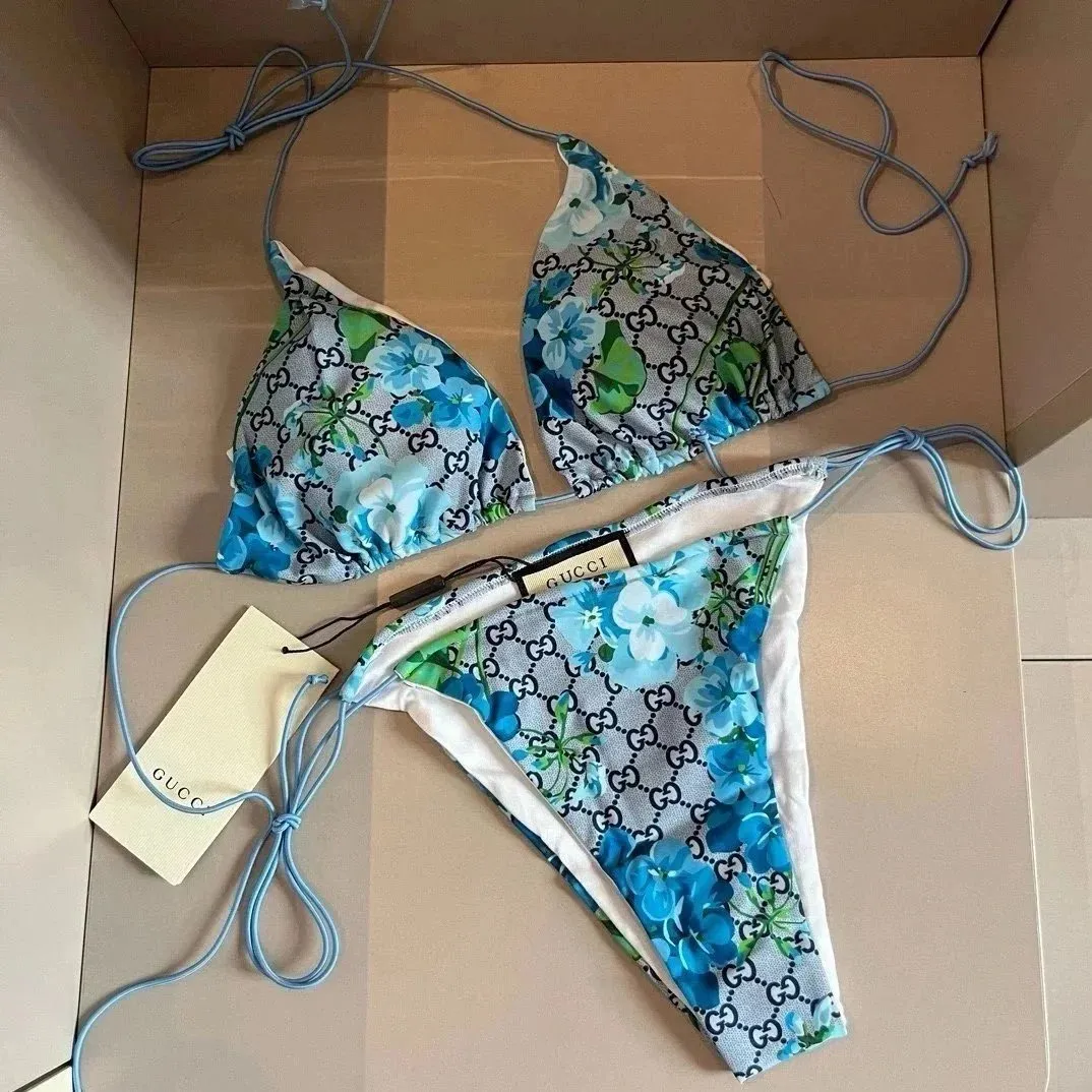 Gucci bikini swimsuit set with blue monogram print, string ties, and white-trim bottoms.