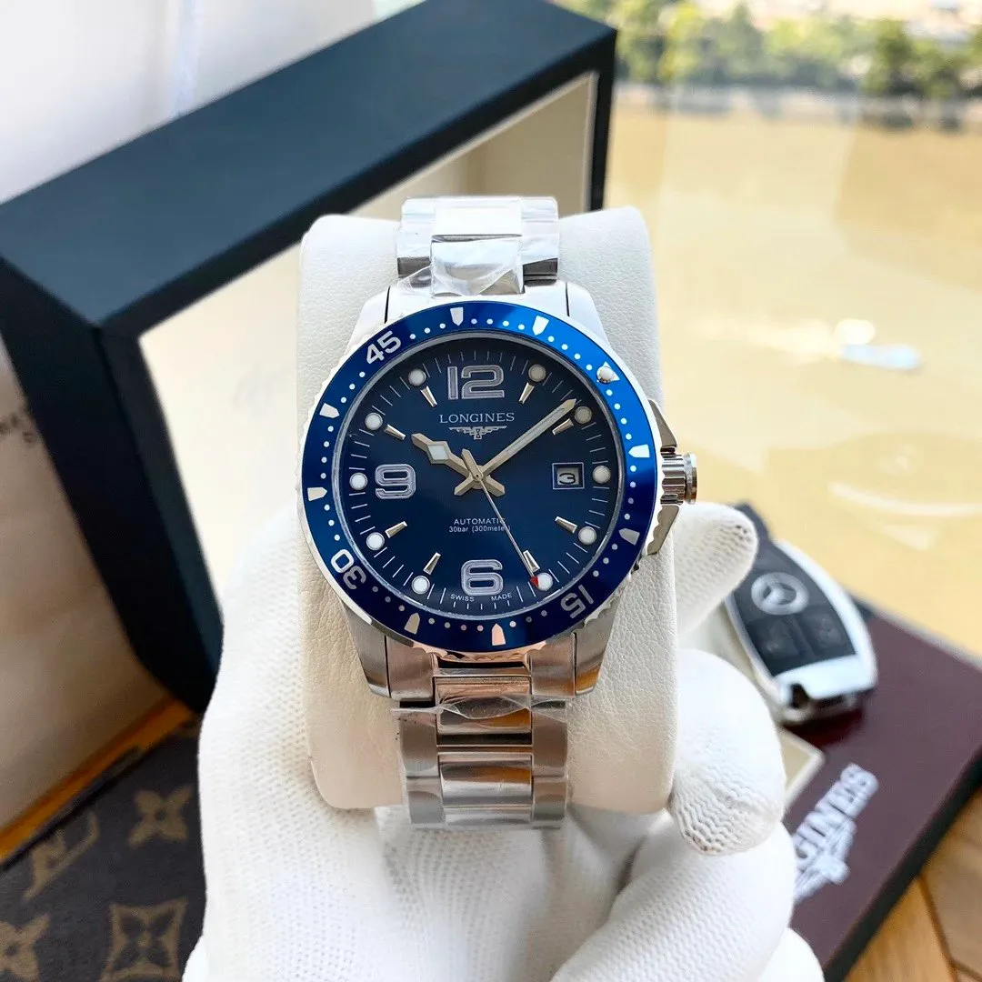 Longines automatic dive watch with a blue dial and steel bracelet on a white cushion.