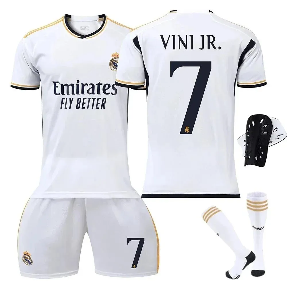Adidas Real Madrid home soccer jersey set with shorts, socks, and shin guards in white and gold.