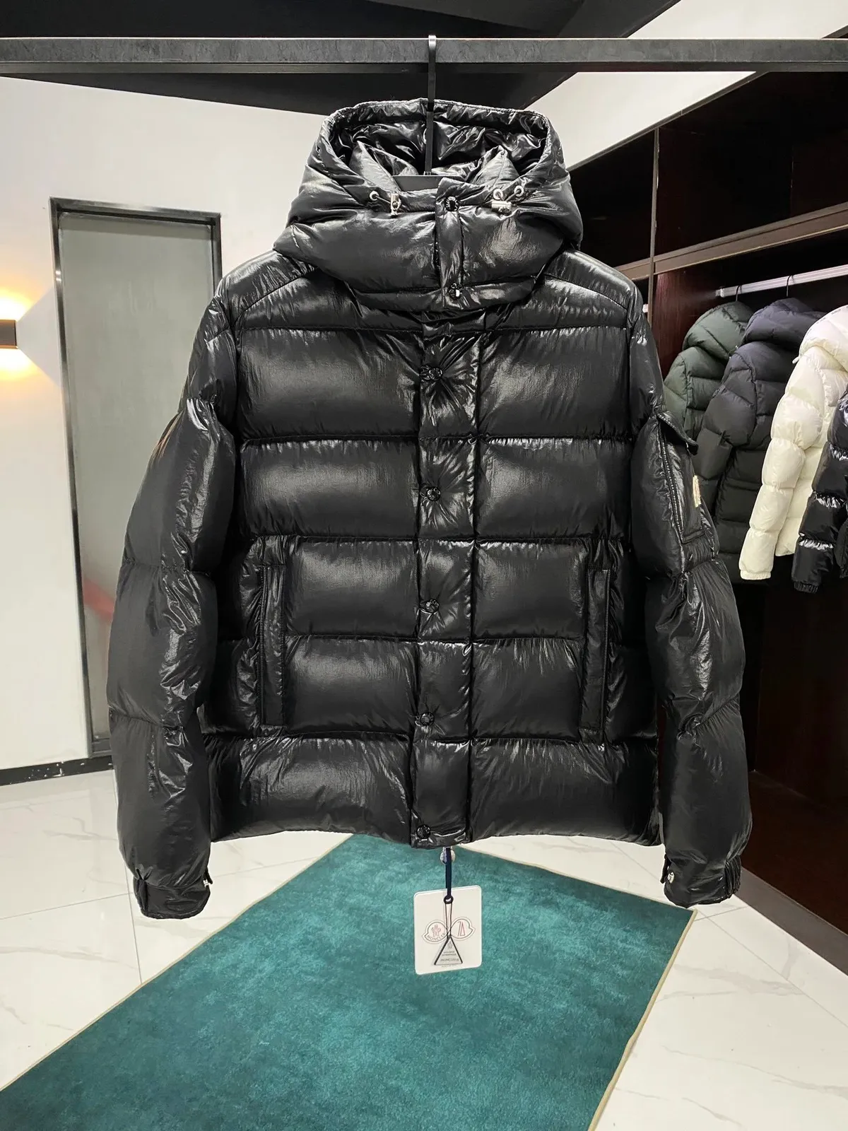 Moncler black puffer jacket with hood, quilted shell, and oversized fit.