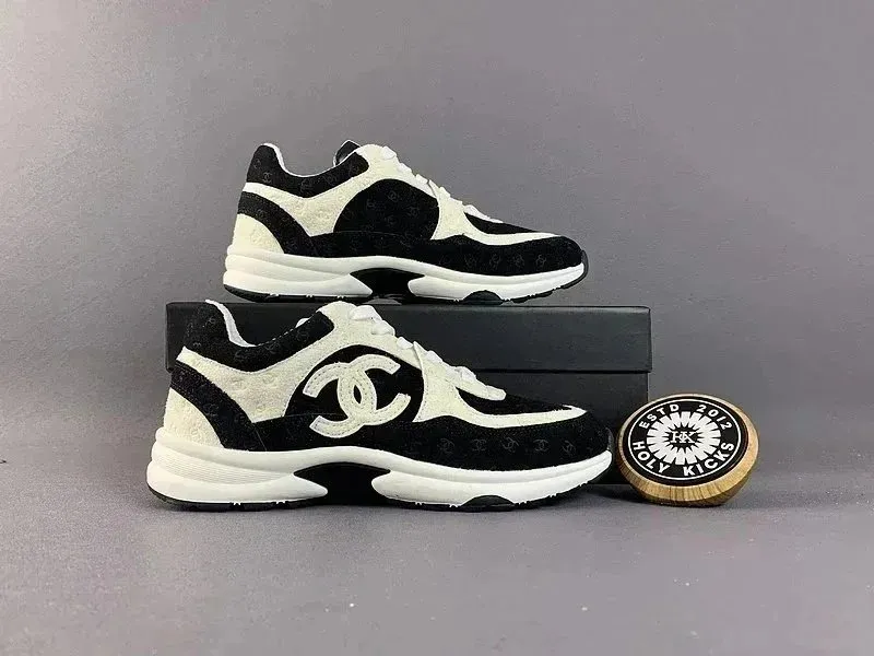 Louis Vuitton sneakers in black, white, and gold with a chunky low-top profile.