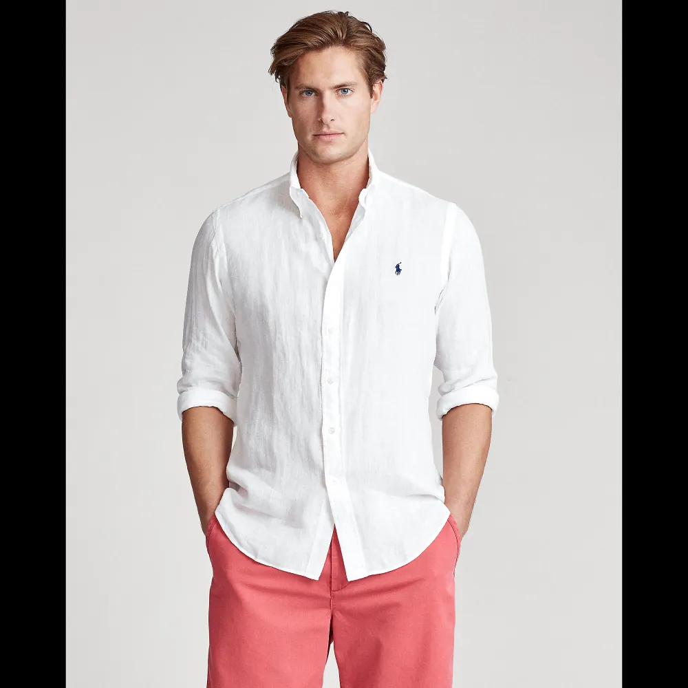 Ralph Lauren white button-down shirt with navy chest logo on a clean studio model