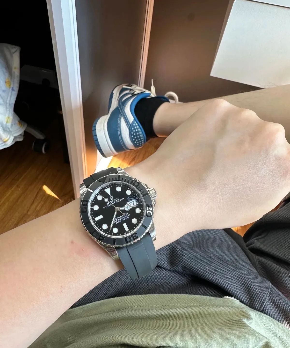 Rolex wristwatch with a black dial, rotating bezel, and black rubber strap.