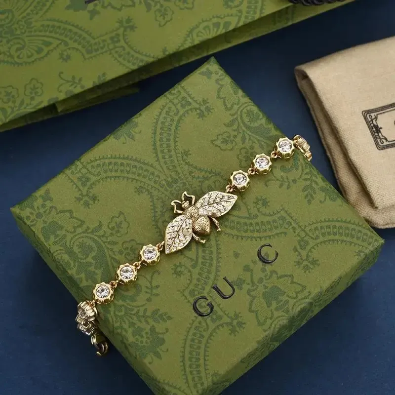 Gucci bransoletka z motywem owada i kryształowymi ogniwami na zielonym tle