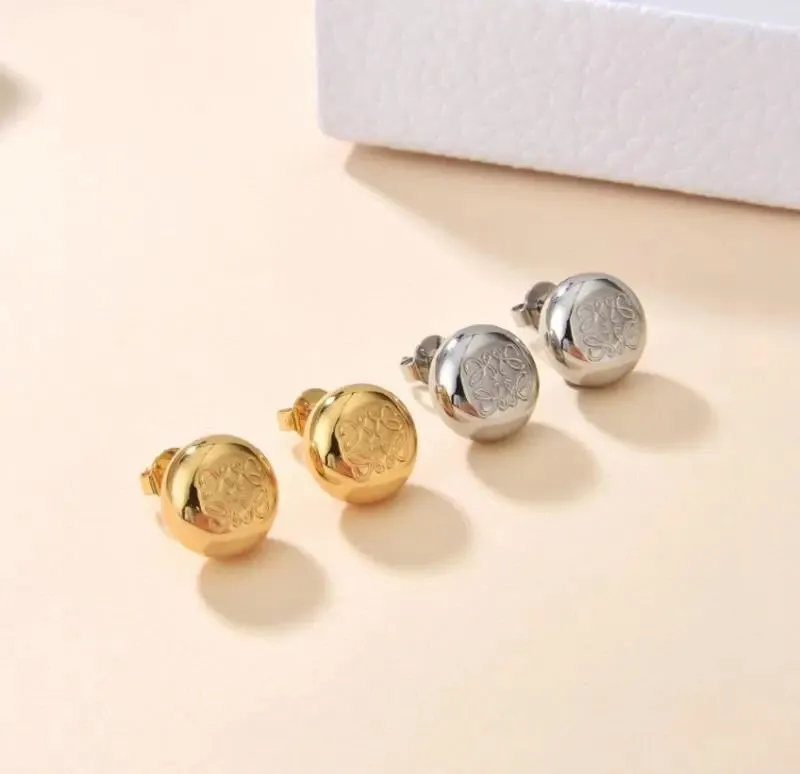 Loewe stud earrings in gold and silver with engraved round disc fronts and post backs.