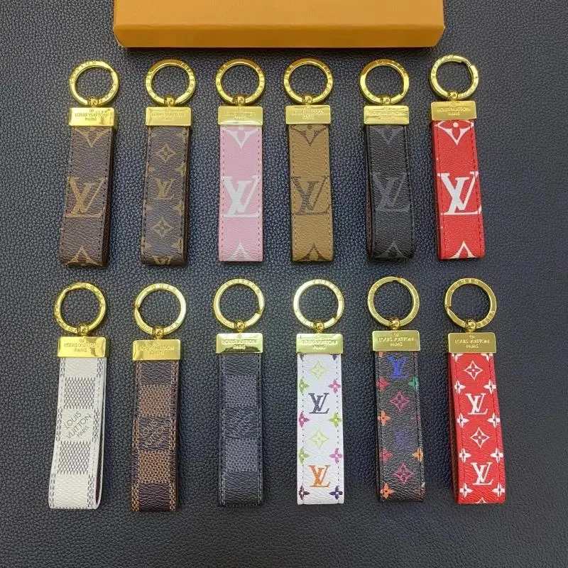 Louis Vuitton keychain set with monogram strap charms and gold-tone plaques on a dark background.