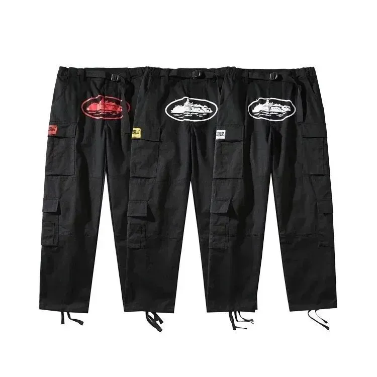 Black Corteiz cargo pants with oval front graphic, cargo pockets, and tapered drawstring hems.