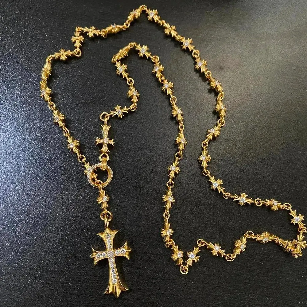 Chrome Hearts necklace z krzyżem i kryształowymi akcentami na ciemnym tle.