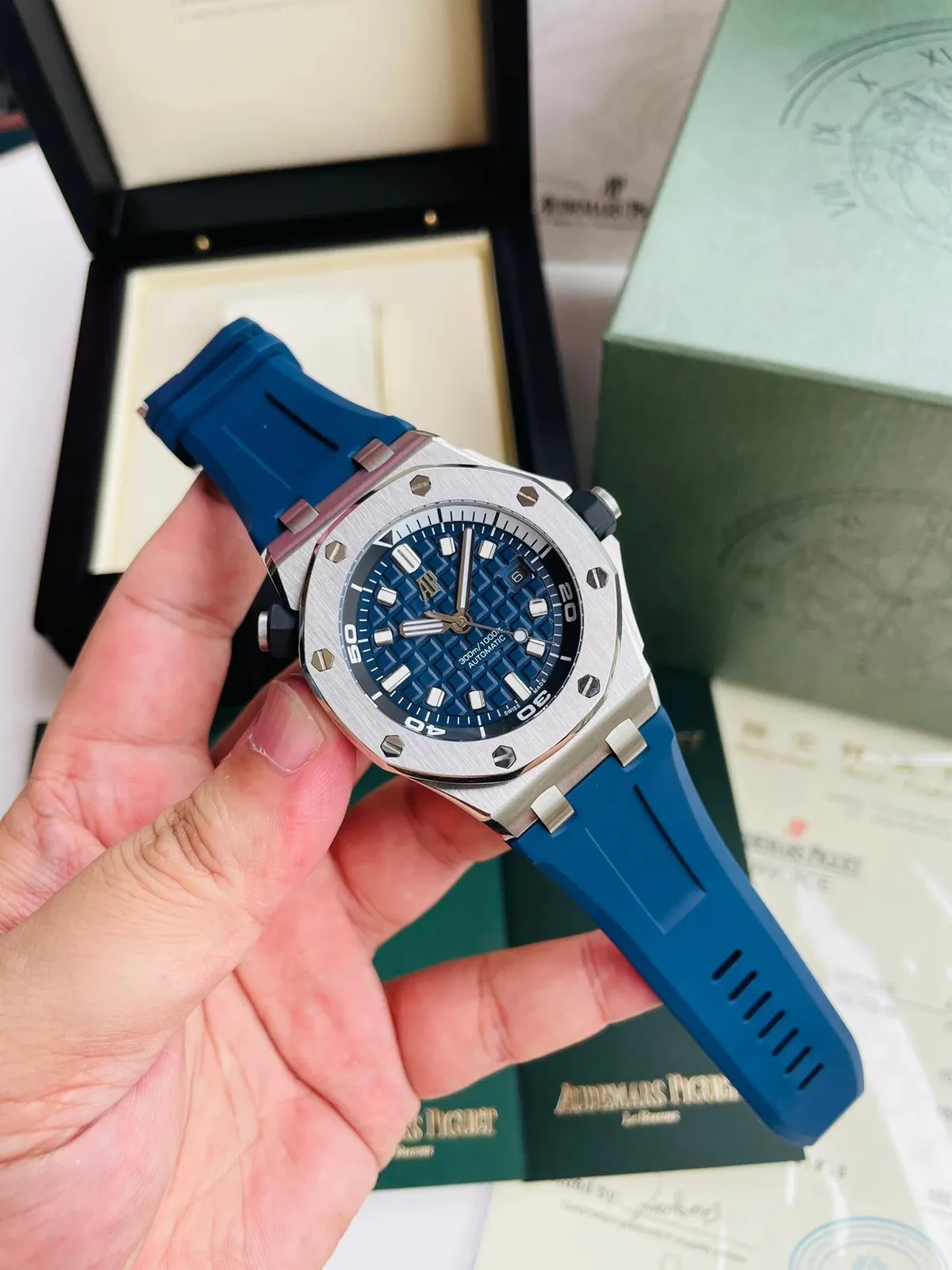 Audemars Piguet sports watch with blue dial, octagonal bezel, and rubber strap.