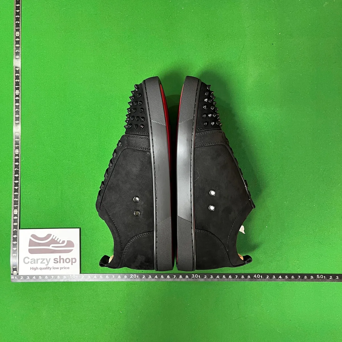 Black Christian Louboutin sneakers with studs, chunky sole, and gray side detail.