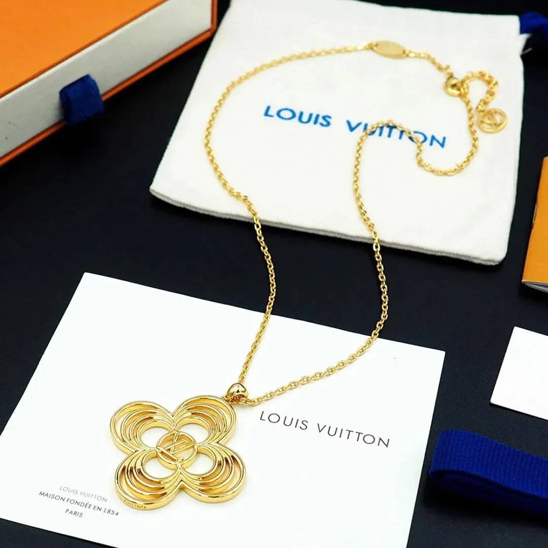 Gold-tone Louis Vuitton pendant necklace with a floral charm on branded packaging.