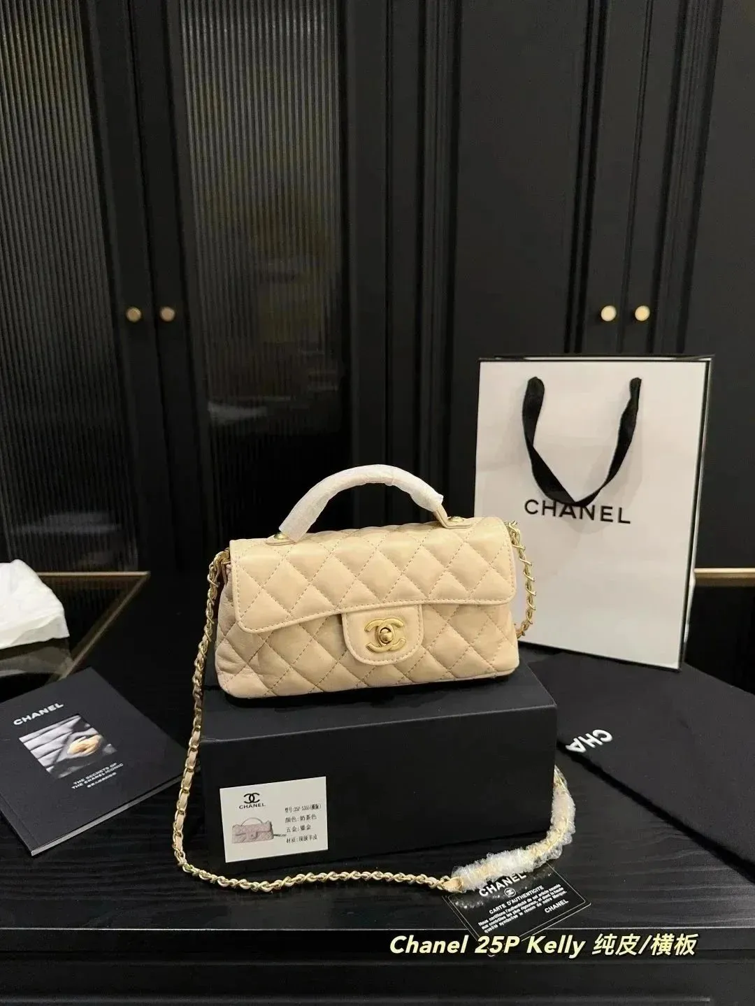 Beżowa Chanel Bag z pikowaniem, złotym łańcuszkiem i zapięciem CC na czarnej podstawie.