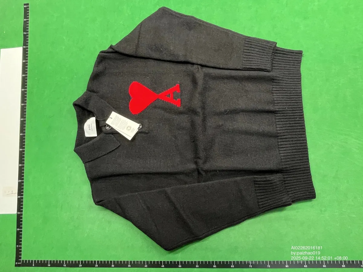 Black Ami knit sweater with a red heart logo on the chest and ribbed trim.
