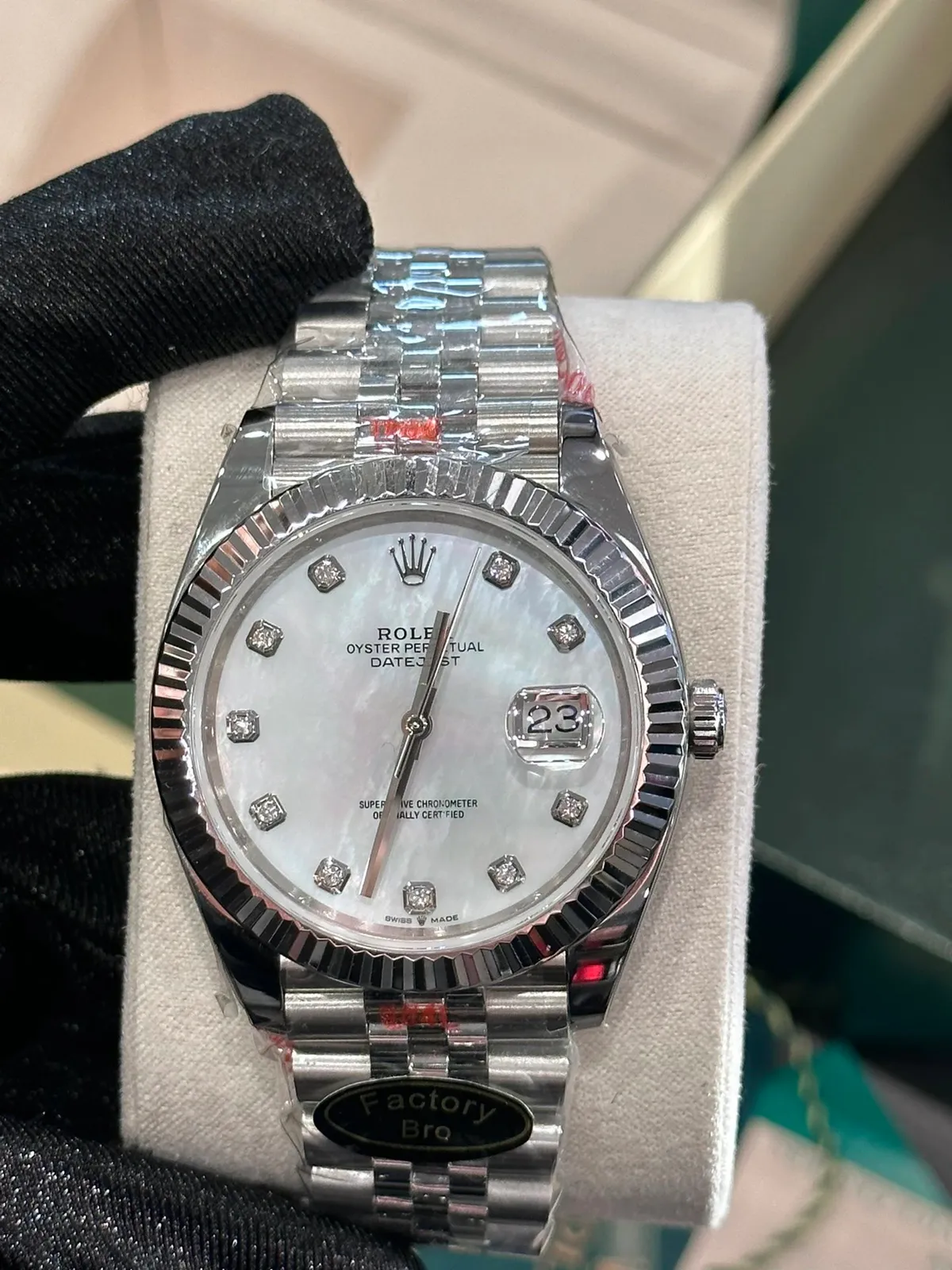Rolex wristwatch with a mother-of-pearl dial, fluted bezel, and metal bracelet.